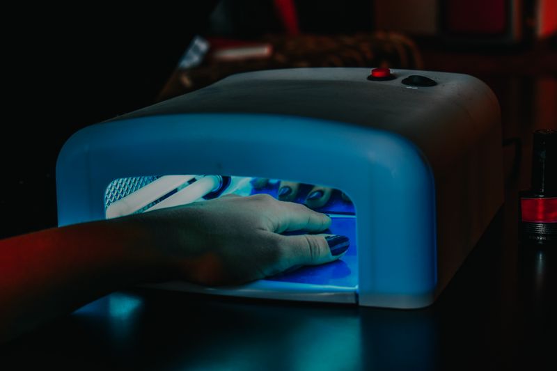 A hand curing gel polish under a UV/LED nail lamp