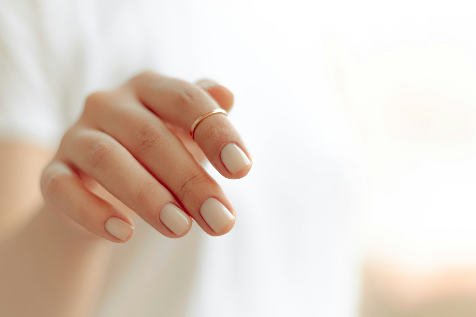 A hand with a neat nude manicure