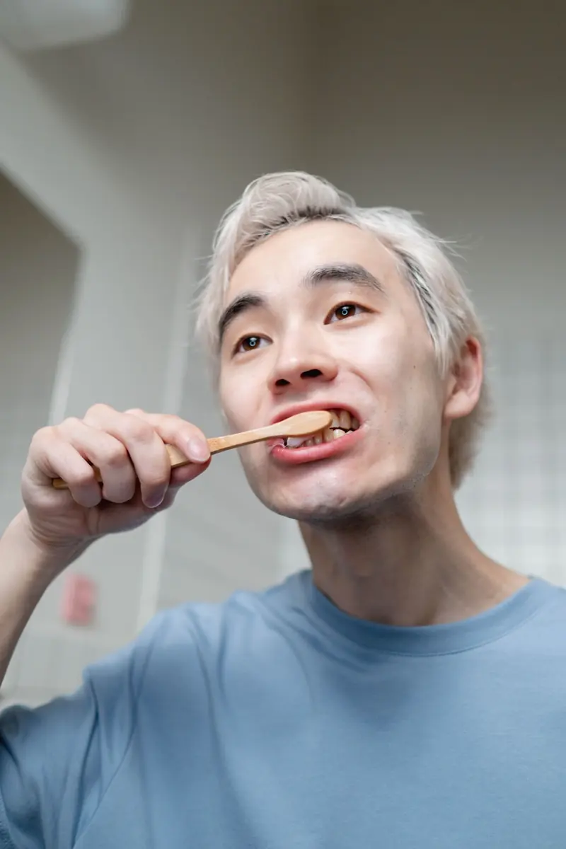 Close-up of a man brushing teeth indoors, emphasizing oral hygiene and healthy morning routine.